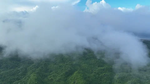 Aerial View of Clouds Drifting Above a Rugged Island Landscape in Indonesia Video stock 312239607