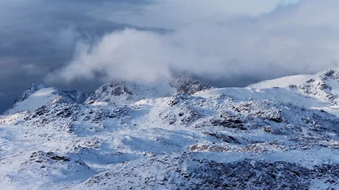 Aerial view of clouds moving over snow covered mountains, Norway 動画素材 342920910