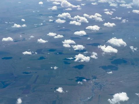 Aerial view of clouds over blue-tinted earth Stock Photos