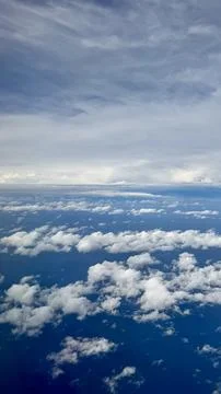 Aerial view of clouds over deep blue ocean from airplane 스톡 사진