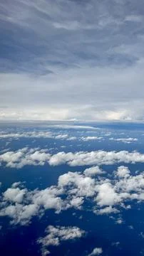 Aerial view of clouds over deep blue ocean from airplane 스톡 사진