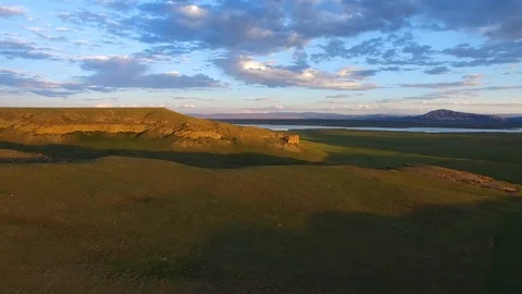 Aerial View Clouds Over Sunshine Lit Ridge Western Plain Landscape, Wyoming Stock Footage 101622286