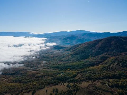 Aerial view of clouds over a valley near a mountain Stock Photos