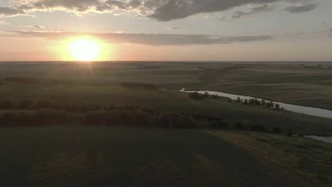 Aerial view on a cloudy sunset over the green valley with trees and lake w Stock Footage 209858793