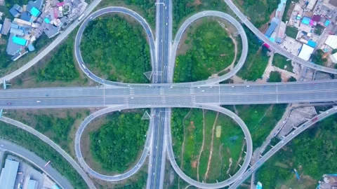 Aerial view of cloverleaf highway interchange with traffic flowing on expressway Stock Footage 342303537