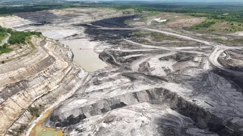 An aerial view of a coal mine featuring a very deep excavation and various .. 動画素材 343251364
