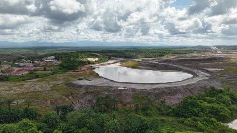 An aerial view of a coal mine pit filled with mud and surrounded by oil pal.. Stock Footage 343248993