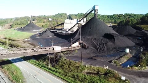 Aerial view of coal mine processing plant with large black storage mounds a.. Stock Footage 337858413