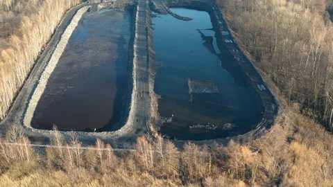 Aerial view of coal sludge and tailing pond with excavators and bulldozer Stock Footage 124545589
