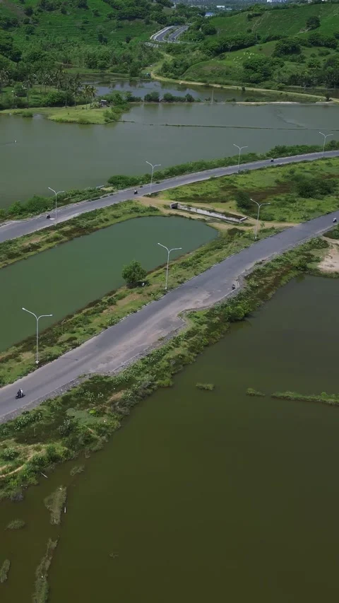 Aerial View Of Coastal Causeway Navigating Salt Flats And Pond Networks Stock Footage 334337671