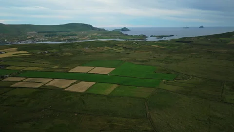 Aerial view of coastal farmland with patchwork fields and distant islands 库存影片 341028251