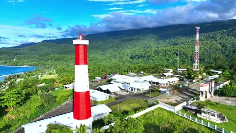 Aerial View of a Coastal Lighthouse Complex Nestled in Lush Green Mountains Stock Footage 301088531