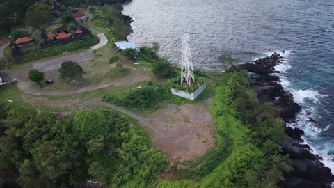 Aerial View of Coastal Lighthouse Tower on Rocky Cliff and Ocean Waves Stock Footage 340490093