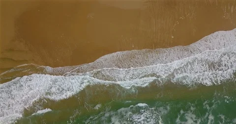 Aerial view of a coastal section with approaching breaking waves and spray Video stock 123408622