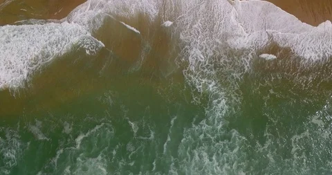 Aerial view of a coastal section with approaching breaking waves and spray Video stock 123413414