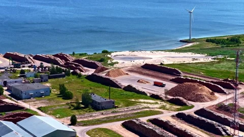 Aerial View of Coastal Timber Processing Factory With Wind Turbines on Baltic Stockbeeldmateriaal 334364635