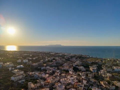 Aerial View of Coastal Town at Sunset with Island on Horizon Stock Photos