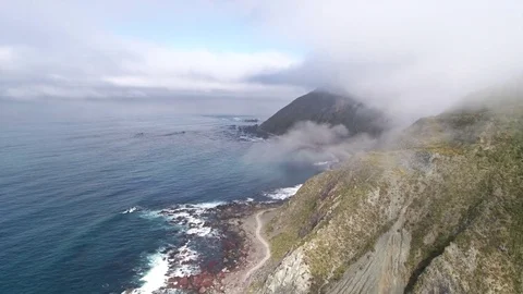 Aerial view of coastline. Flight through the clouds, over seashore - New Zealand Stock Footage 76009958