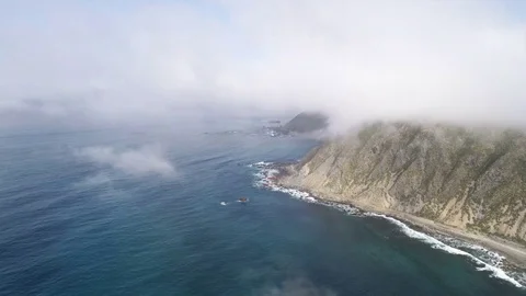 Aerial view of coastline. Flight through the clouds, over seashore - New Zealand Vidéo 76085126