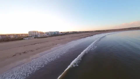Aerial view of coastline at sunset, beach, road, and dunes Stock Footage 344582465