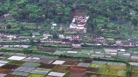 Aerial view of colorful patchwork farm fields and hillside village at Bukit Video stock 337197764