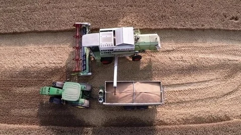 Aerial View of Combine Unloading Grain into Tractor During Harvest 2026 Stock Footage 81263702
