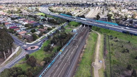 Aerial view of a commuter train passing under a highway overpass Stock Footage 341919183