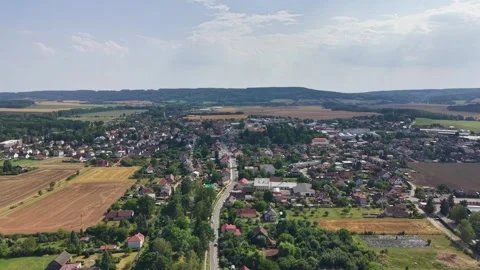 Aerial view of compact town core surrounded by farmland and rolling hills under Stock Footage 345170914