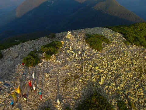 Aerial view of the company of friends who stand on top of the mountain Stock Footage