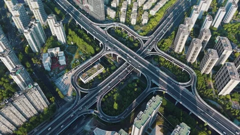 Aerial view of a complex highway interchange surrounded by tall buildings and Stock Footage 307907236