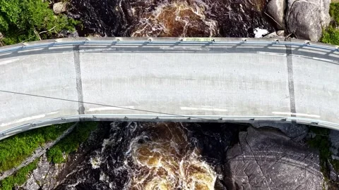 Aerial view of a concrete bridge over a rushing river in a canyon in Norway Stock Footage 341540284