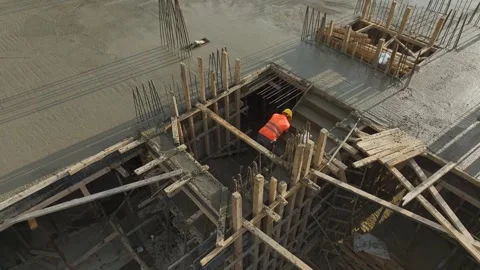 Aerial View: Concrete leveling in progress as a worker refines the stair landing Stock Footage 296075563
