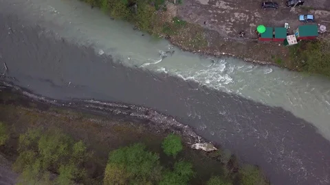 Aerial View of the Confluence of Two Rivers in a Mountain Valley with Road Stock Footage 129251840