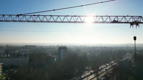 Aerial view of construction crane at building site, capturing the sunlit skyline Vidéo 335885457