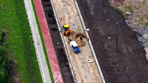 Aerial view of a construction crew building a new road and bike path Stock Footage 313890402