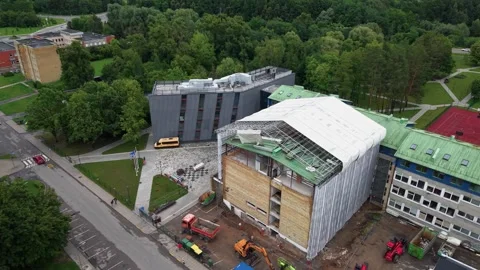 Aerial View of Construction Site and Modern Campus Buildings Surrounded by Lush Stock Footage 341996656