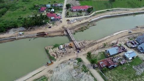 Aerial view of the construction site of a bridge over the river Stock Footage 294978147