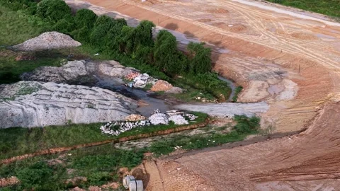 Aerial view of construction site with dirt road riverbank and green plants 스톡 동영상 336816688