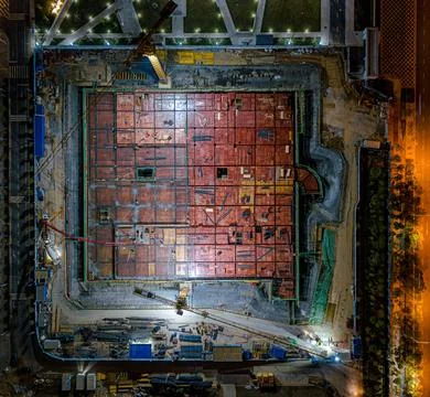 Aerial view of a construction site featuring a large amount of red bricks at nig 스톡 사진