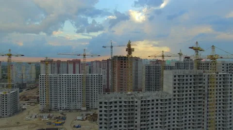 Aerial view. Construction site with many cranes at a big city. Sunset time. Stock Footage 63750869