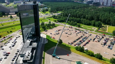 Aerial view construction site: skyscraper and a mobile crane with extended boom Stock Footage 146676818