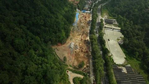 Aerial View of Construction Site Surrounded by Lush Greenery and Forest Stock Footage 316450449