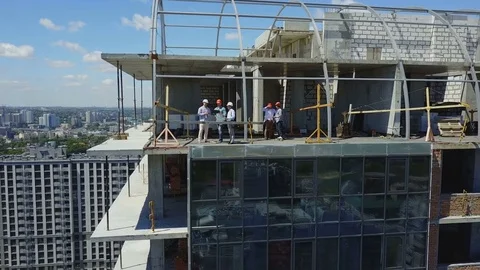 Aerial View Of Construction Site With Team Of Builders On Roof Discussing Plan Stock Footage