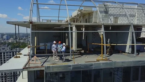 Aerial View Of Construction Site With Team Of Builders On Roof Discussing Plan Stock Footage 79752860