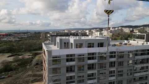 Aerial view of a construction site with a tower crane operating above a multi-st Stock Footage 323234080