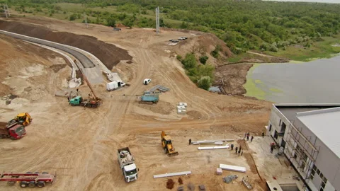 Aerial view of construction site with vehicles, cranes, and workers. Road Stock Footage 287300609