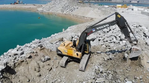 Aerial view construction site where excavation  machine is working by the coast Stock Footage 104193554