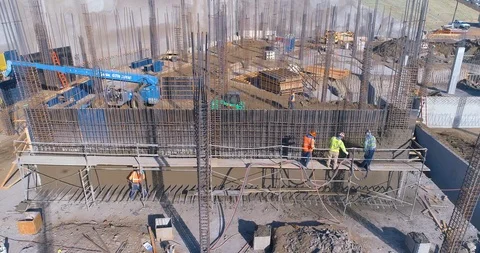 Aerial view of construction site workers builing concrete wall on a job site Stock Footage 85651558