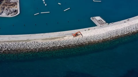Aerial view of the construction of the stone defense of the marina Stock Footage 118853401