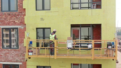 Aerial View at Construction Worker in Safety Hat in Construction hoist Stock Footage 143764188